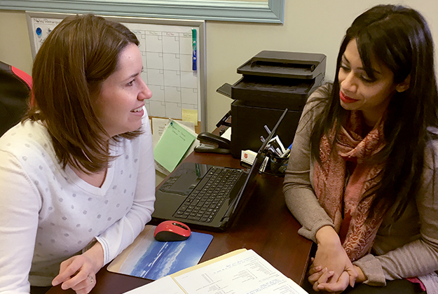 Caseworker Julie (left) sits with Pathway of Hope participant Leena (right).